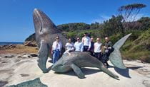 Group of people standing with large whale sculptures in Kamay-Botany Bay National Park. Photo: Aaron Hughes &copy; Burraga Foundation