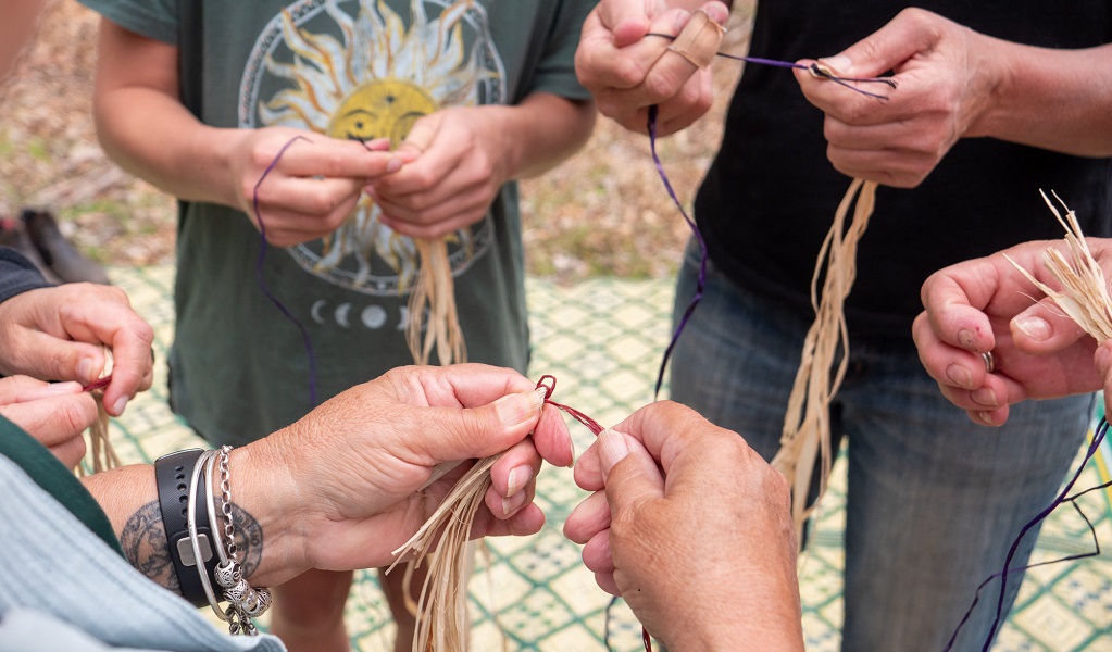 A group starts a weaving project during a traditional bushcraft workshop in Mimosa Rocks National Park. Credit: Jessica Taunton &copy; DCCEEW