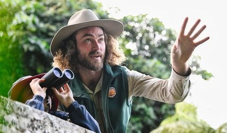 Child holds binoculars towards the sky as a Discovery Ranger explains what he might see. Credit: Adam Hollingworth/DCCEEW &copy; DPE