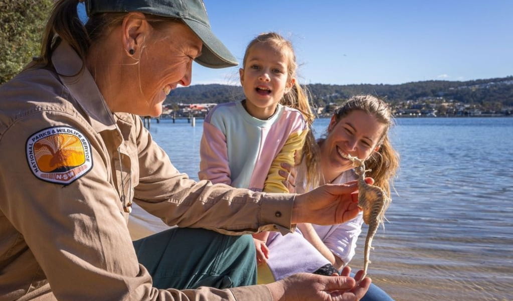 NPWS ranger wearing cap showing young girl and mother seahorse. Photo: David Rogers &copy; DCCEEW