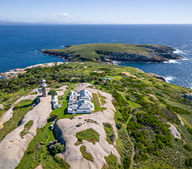 Aerial drone view above Barunguba Montague Island looking north across the lighthouse and cottages towards the sea. Photo: Johny Spencer © DCCEEW