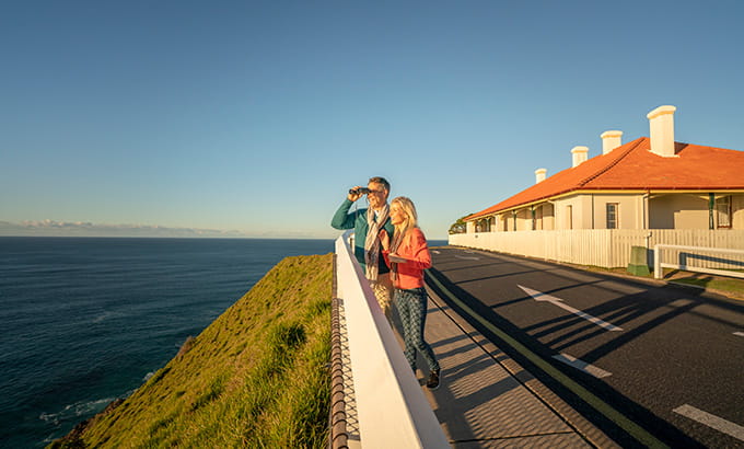 People whale watching near the Assistant Lighthouse Keepers Cottages, Cape Byron. Credit: John Spencer &copy; DCCEEW