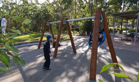 Children play on the swings at Village Green picnic area and playground, Blue Gum Hills Regional Park. Credit: Stuart Cohen, Bottle Brush Media © DCCEEW