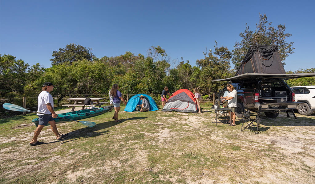 Campers heading off with their kayak at Mibanbah-Black Rocks campground. Credit: John Spencer &copy; DCCEEW