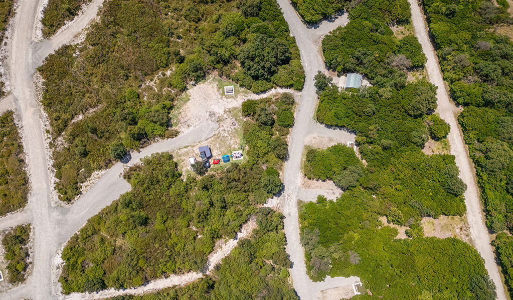 Aerial view of campsites, bushland and the access road at Mibanbah-Black Rocks campground. Credit: John Spencer &copy; DCCEEW