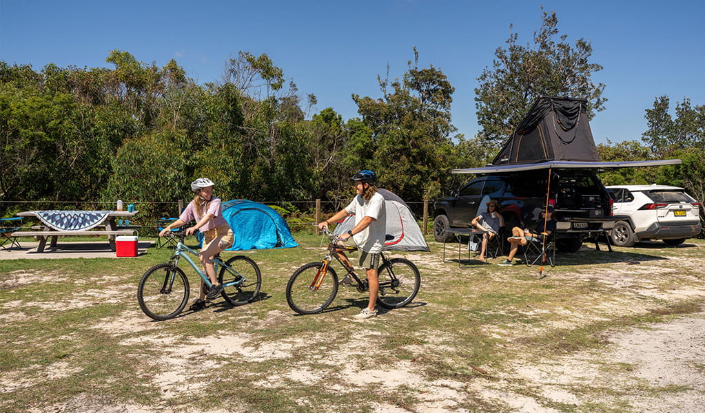 Campers heading off on their bikes at Mibanbah-Black Rocks campground. Credit: John Spencer &copy; DCCEEW