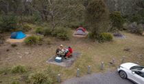 A group of campers eating at the picnic table next to their campsite at Bungonia campground. Photo: John Spencer/DCCEEW &copy; DCCEEW