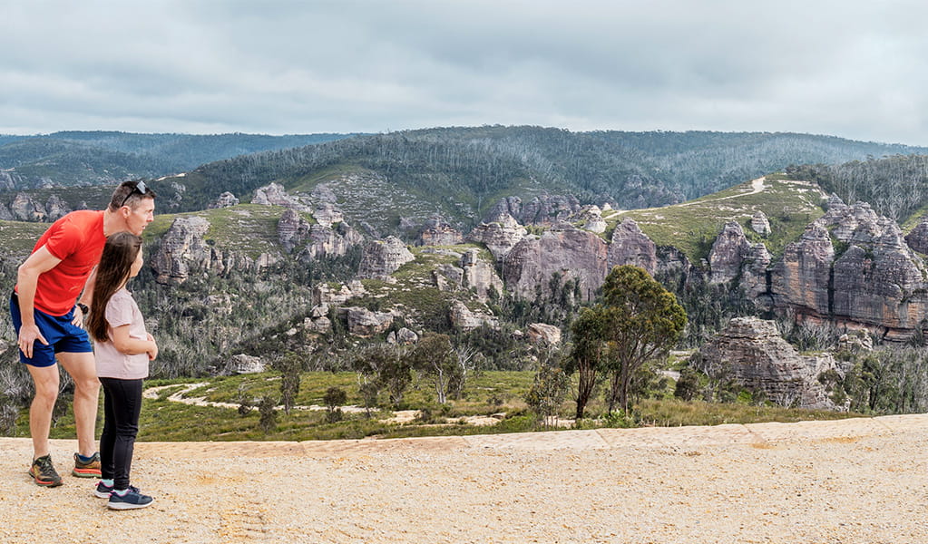 A father and child looking out at pagodas from Lost City lookout in Gardens of Stone State Conservation Area. Credit: Simone Cottrell &copy; DCCEEW