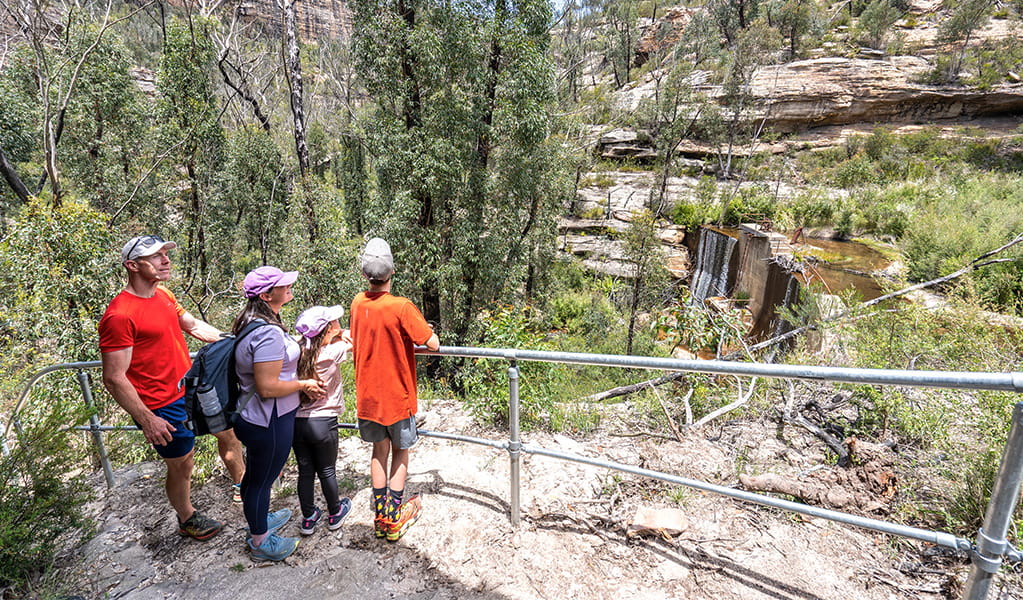 A family resting at a viewpoint overlooking a historic heritage dam that once supplied water to Lithgow. Credit: Simone Cottrell &copy; DCCEEW