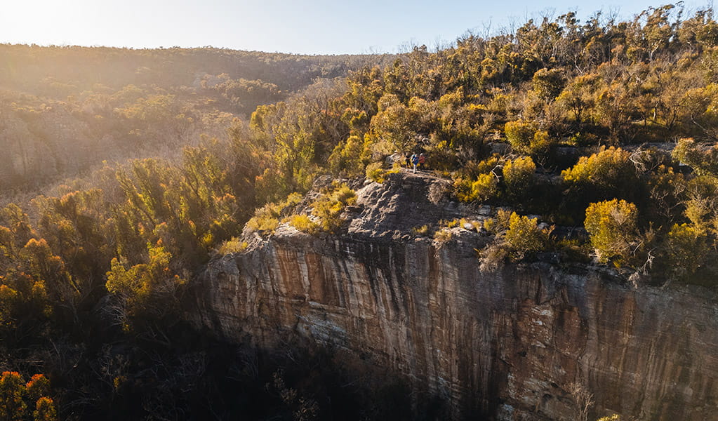 An aerial image of sunrise over a sheer sandstone cliff near the Pagoda walk in Gardens of Stone State Conservation Area. Credit: Harrison Candlin &copy; Harrison Candlin