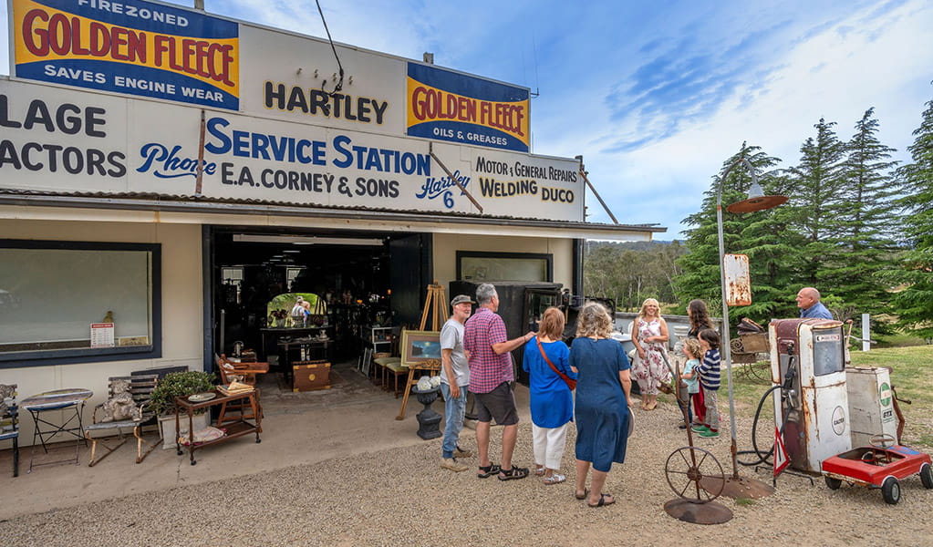 Visitors outside the antique shop in Corneys Garage, Hartley Historic Site, near Lithgow. Credit: John Spencer &copy; DCCEEW