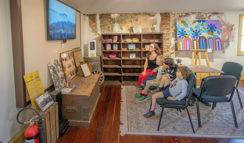 Visitors watching an informative video inside Hartley Historic Site Visitor Centre. Credit: John Spencer &copy; DCCEEW