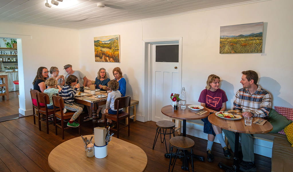 People eating and drinking at tables inside The Postmistress Cafe and Store in Hartley Historic Village. Credit: John Spencer &copy; DCCEEW