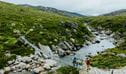 2 bushwalkers crossing a creek along Illawong walk in the Thredbo-Perisher area of Kosciuszko National Park. Credit: Daniel Parsons / DCCEEW &copy; Caravel Content