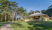 Roto House and the path leading up to it, surrounded by green lawn, gum trees and blue sky, Roto House Historic Site. Credit: John Spencer &copy; DCCEEW