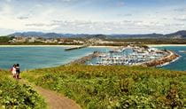 Two people enjoying the view of the Muttonbird Island Nature Reserve marina. Photo: Rob Cleary