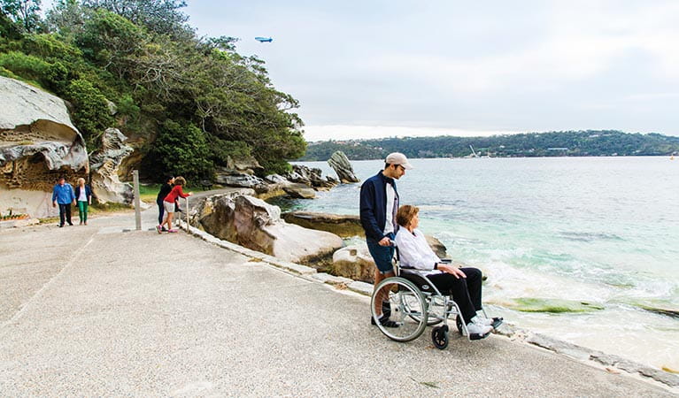 Wheelchair user admiring views of Shark Beach from the wheelchair accessible path in Nielsen Park. Photo: Simone Cottrell/DPIE