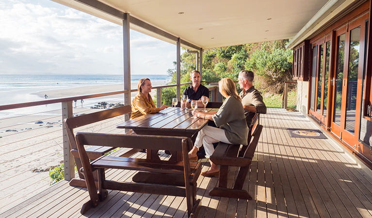 Friends drinking on the balcony of Imeson Cottage. Photo: Sera Wright/DPIE.