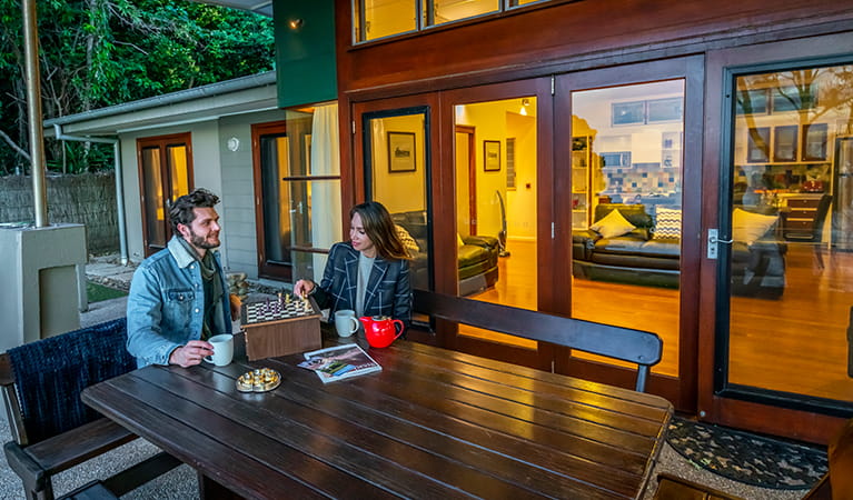 Guests playing chess with tea outside Mildenhall cottage. Photo: DPIE/John Spencer