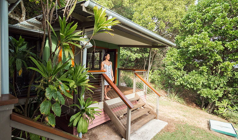 Woman walking out of her bedroom into the secluded bush at Thomson Cottage. Photo: Sera Wright/DPIE