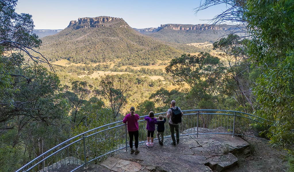 2 adults and 2 kids taking in views of Donkey Mountain and Wolgan Valley at the lookout on Glow Worm Tunnel walking track. Credit: John Spencer &copy; DCCEEW