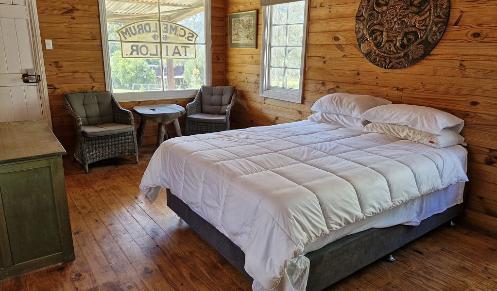 Inside The Tailors Room, showing a double bed, cabinet, 2 chairs and a small table, the front door and front and side windows, Yerranderie Regional Park. Photo: Hassan Elbatoory &copy;DCCEEW.