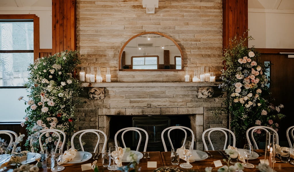 Wedding set up at Audley Dance Hall, with a rustic fireplace and floral display as the backdrop. Photo: Scott Surplice photography &copy; Scott Surplice photography