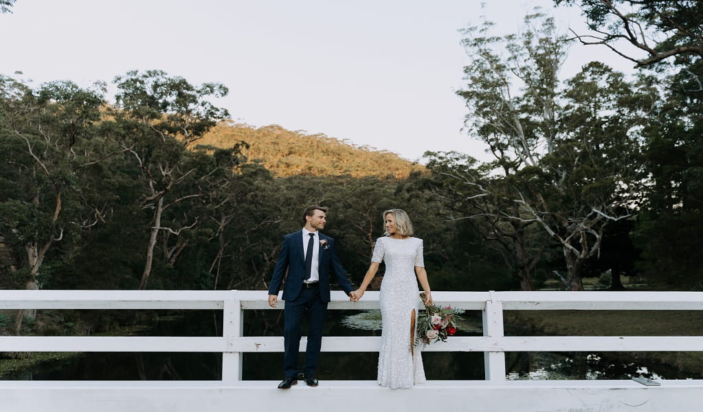 Couple poses for a photo after exchanging vows, framed by the lush green bush setting at Royal National Park. Photo: Rick Liston &copy; Rick Liston