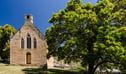 The exterior of Former St Bernards Church next to trees in Hartley Historic Site. Photo: John Spencer &copy; DPIE